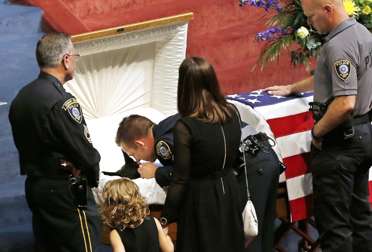 Oklahoma City police officer Sgt. Ryan Stark, center, leans over the casket of his canine partner, K-9 Kye, following funeral services for the dog in ...