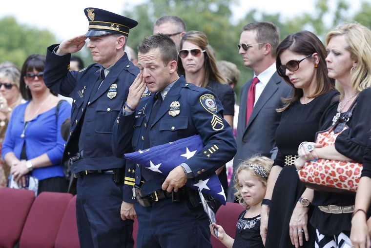 Oklahoma City police officer Sgt. Ryan Stark, center, wipes a tear from his eye following funeral services for his canine partner, K-9 Kye, in Oklahom...