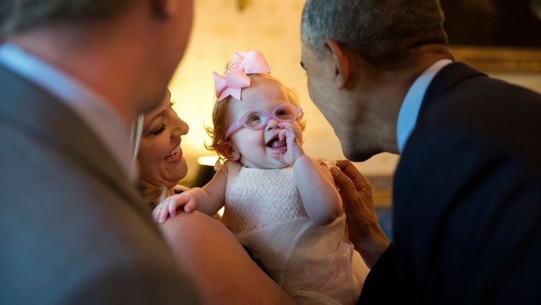 President Barack Obama greets Zoe Mahan, daughter of  Hunter and Kandi Mahan, during a reception for the 2013 President's Cup championship golf teams ...