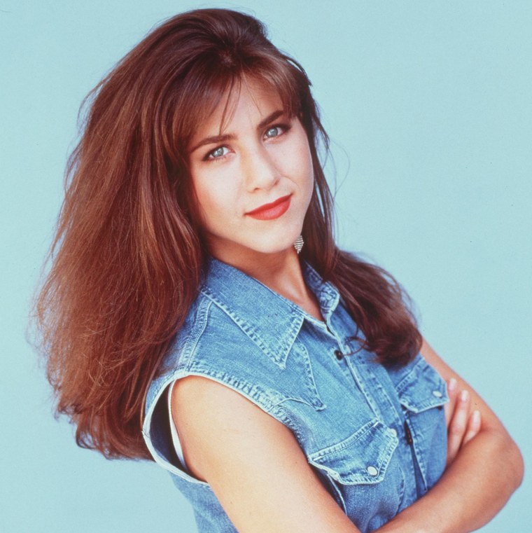 1992: Before \"Friends,\" Aniston sported a fuller, fluffier hair look while starring in the TV show \"The Edge.\"