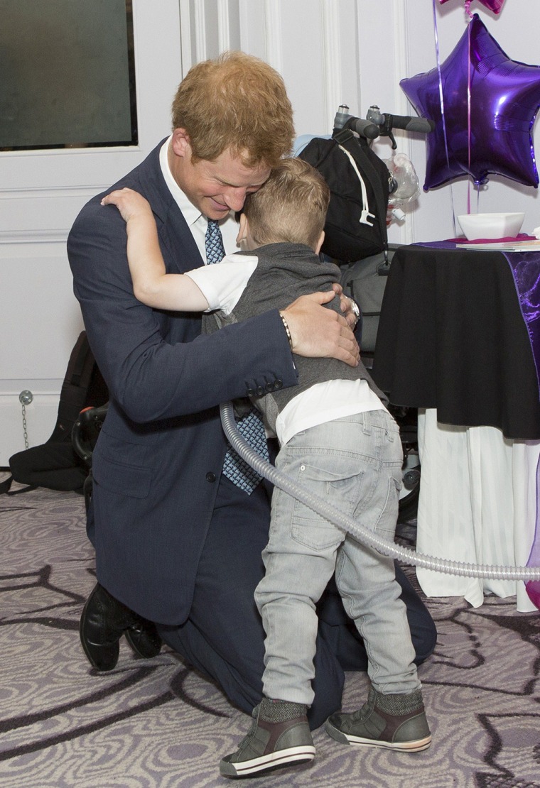 Britain's Prince Harry (L) embraces Carson Hartley, 4, as he attends the WellChild Awards in London on September 22, 2014. The awards recognise the co...