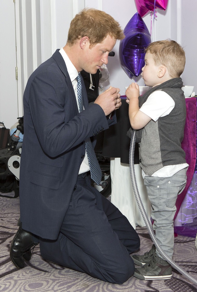 Britain's Prince Harry (L) meets Carson Hartley, 4, as he attends the WellChild Awards in London on September 22, 2014. The awards recognise the coura...