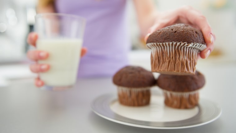 Closeup on teenager girl with milk taking chocolate muffin; Shutterstock ID 139199882; PO: today.com