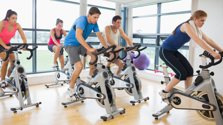 People working out on exercise bikes in a gym