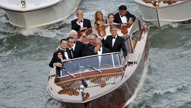 George Clooney waving from his boat in Venice with Ramzi Alamuddin, father of Amal Alamuddin, his father Nick Clooney, and his mother Nina Bruce, second from right back row.