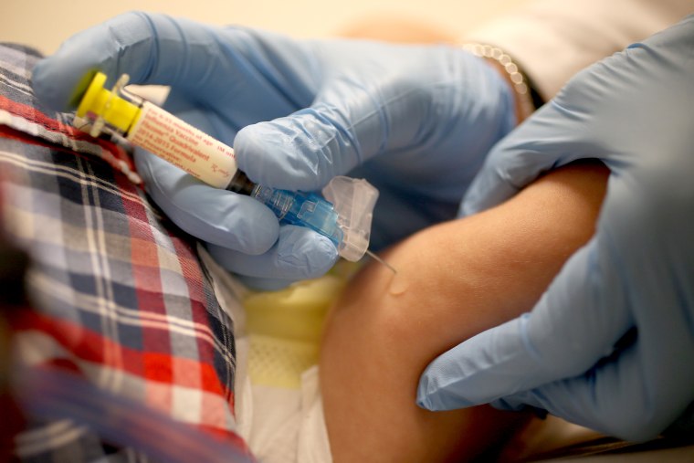 CORAL GABLES, FL - JANUARY 07:  Pediatrician Dr. Amanda Porro M.D. delivers a flu vaccination to an infant's leg during his visit to the Miami Childre...