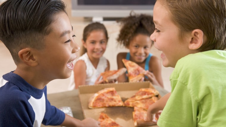 Four young children indoors eating pizza smiling; african; american; boy; caucasian; child; childrens; delivery; eat; enjoying; ethnic; fast; female; ...