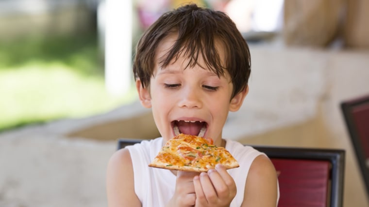 boy eating pizza in a restaurant; adorable; anticipation; anxious; appetite; appetizing; baked; boy; charming; child; cooked; crust; cute; delicious; ...