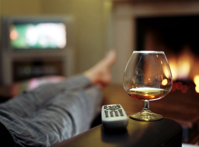 Person in in living room (focus on brandy glass and remote control) couch potato lazy laziness relax relaxed relaxation telelvision drink alcohol fire...