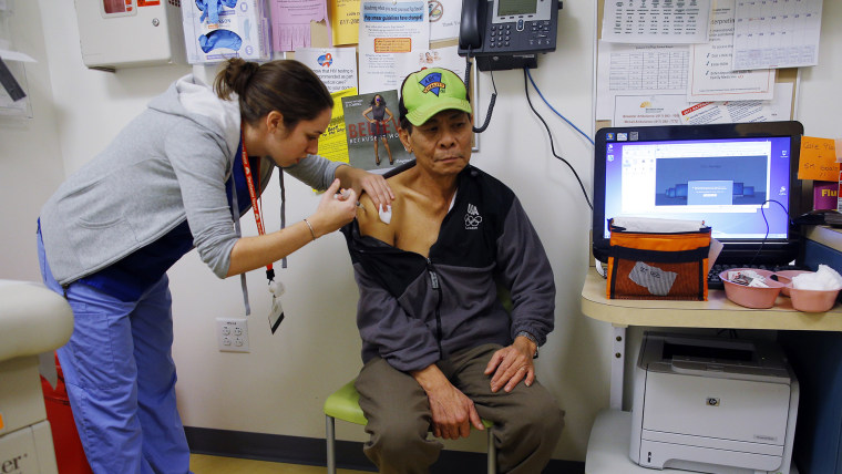 Anthony Ngyen recibe una vacuna contra la influenza de la enfermera Maya Kahn-Woods en Dorchester House, una clínica en Boston, Massachusetts, el 12 de enero de 2013.