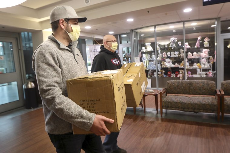 Ryan Dempsey, frente, y Tyler Stephens, de The East End Group, una empresa de construcción y contratación general, entregan una donación de unas 1,000 máscaras por el coronavirus al Hospital St. Charles en Port Jefferson, Nueva York, el 25 de marzo de 202