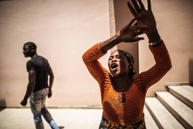Image: A distressed Gabonese woman waits with other relatives at the Libreville Magistrate Court
