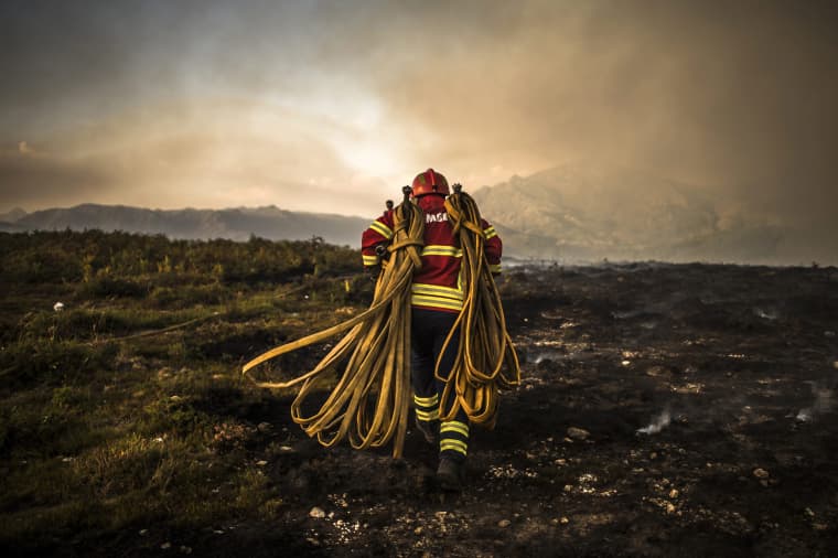 Image: A firefighter works at the scene of a wildfire in Vila do Soajo