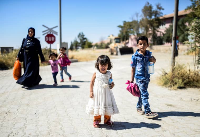 Image: Syrian refugees walk on their way back to the Syrian city of Jarabulus