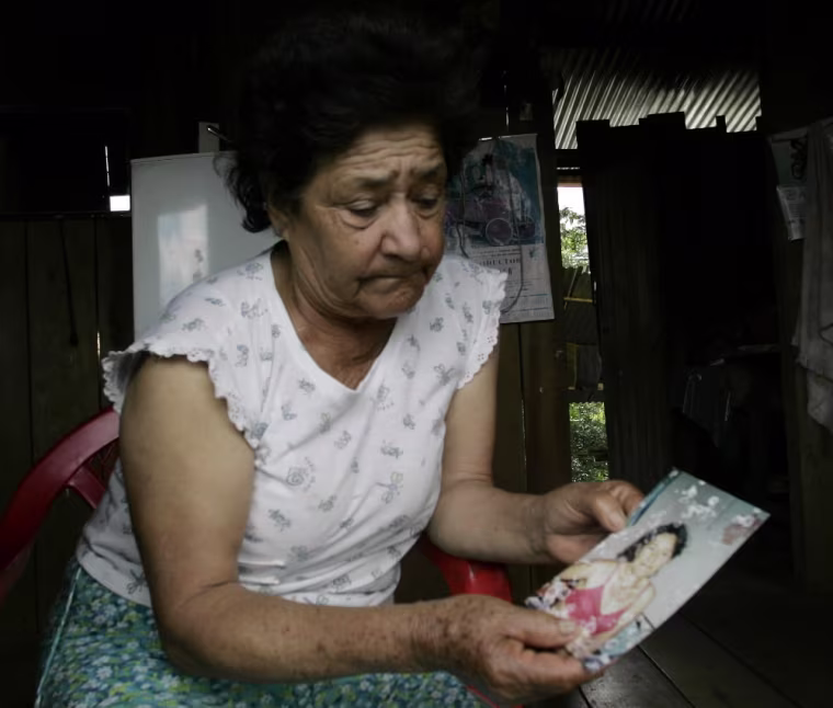 Mercedes Jimenez shows a photograph of her daughter Mercedes Jaramillo, who suffers from skin problems which her family fear is skin cancer, in her home in Lago Agrio, Ecuador on Aug. 4, 2008. The Amazon Defense Coalition claims that Texaco haphazardly dumped 18 billion gallons of toxic wastewater in virgin forests and, as a result, residents suffered abnormally high cancer rates. (AP Photo/Dolores Ochoa)