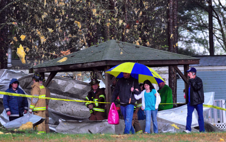 **CORRECTS DATE** Residents leave Wylie Overlook mobile home park off Landing Road in Belmont, N.C. after a storm ripped the roof off nearby Parkdale Mills distribution center and showered the neighborhood with debris and severely damaging their mobile home on Sunday, March 28, 2010. (AP Photo/The Charlotte Observer, Robert Lahser)