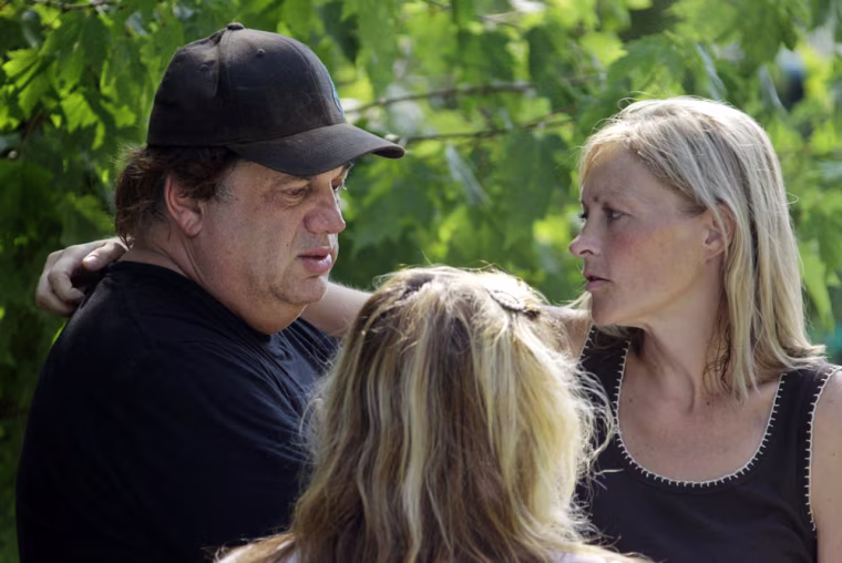 Image: Ellen Vajda, right, comforts Sam Mazzola outside Mazzola's exotic animal sanctuary in Columbia Station, Ohio