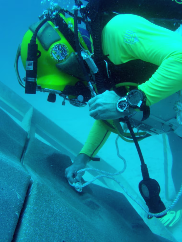 A diver anchoring to a simulated asteroid surface created for NASA's underwater NEEMO 15 mission.