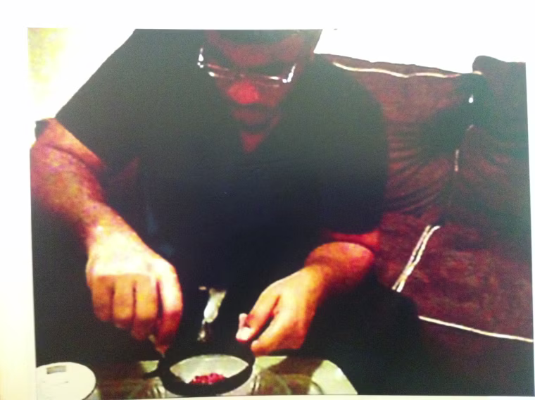 This New York Police photo, displayed at Mayor Michael Bloomberg's news conference, Nov. 20, shows Jose Pimentel inside his apartment, taking material off matches to build a pipe bomb, according to Police Commissioner Ray Kelly.