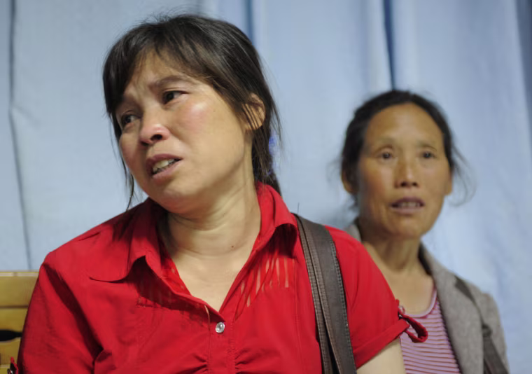 Relatives wait outside a ward where people injured in a factory explosion are treated at a hospital in Chengdu, China, in 2011. The Foxconn factory built iPads for Apple.