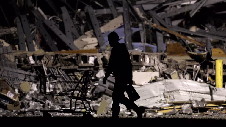Image: An emergency worker searches a Walmart store that was severely damaged by a tornado in Joplin, Mo.