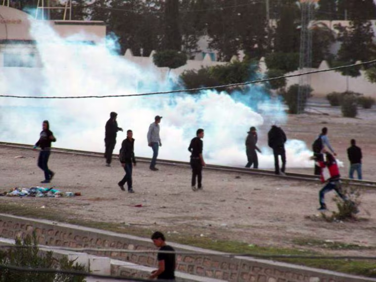 Image: Demonstrators clash with police forces, unseen, in Kasserine, a city of Tunisia's impoverished central region