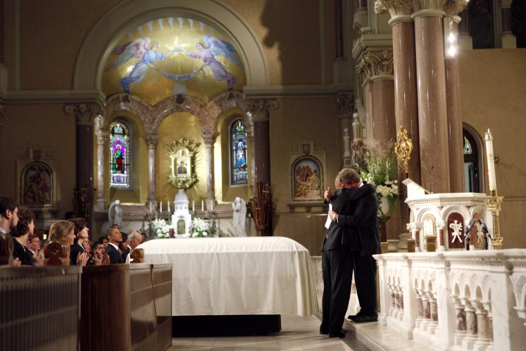 Image: U.S. Senator Edward Kennedy's sons Congressman Patrick and Edward Jr. hug at the altar during eulogies at funeral services for Senator Kennedy in Boston