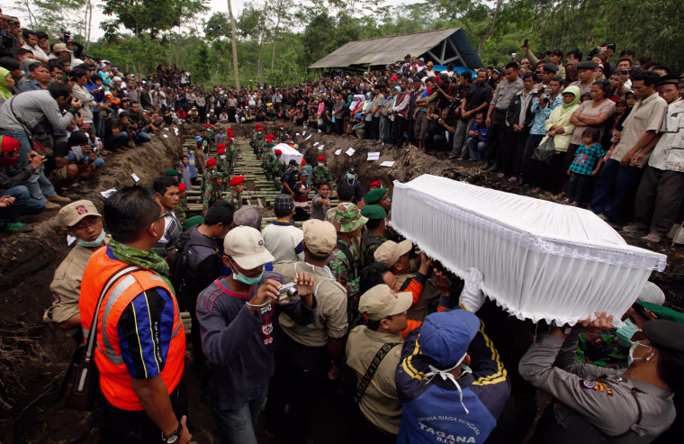 Image: Indonesian policemen and volunteers carry the coffin of a victim of the Mount Merapi eruption during a mass burial at Umbulhardjo village in Sleman, near the ancient city of Yogyakarta