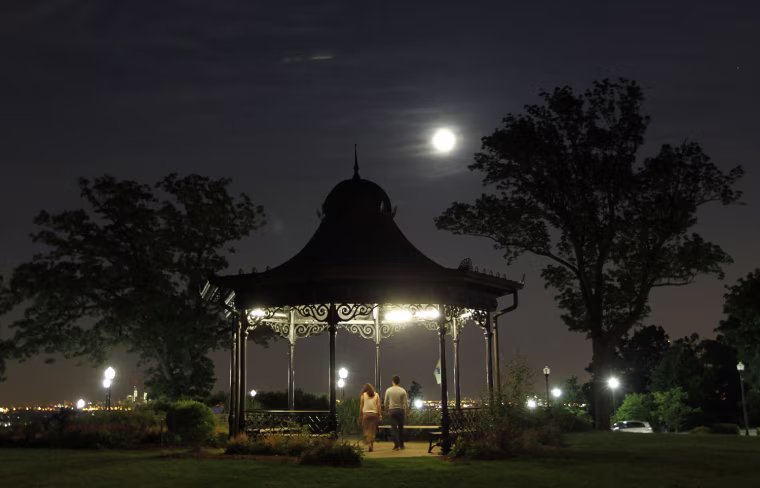 Image: People walk through a gazebo as a super moon rises in West Orange, New Jersey