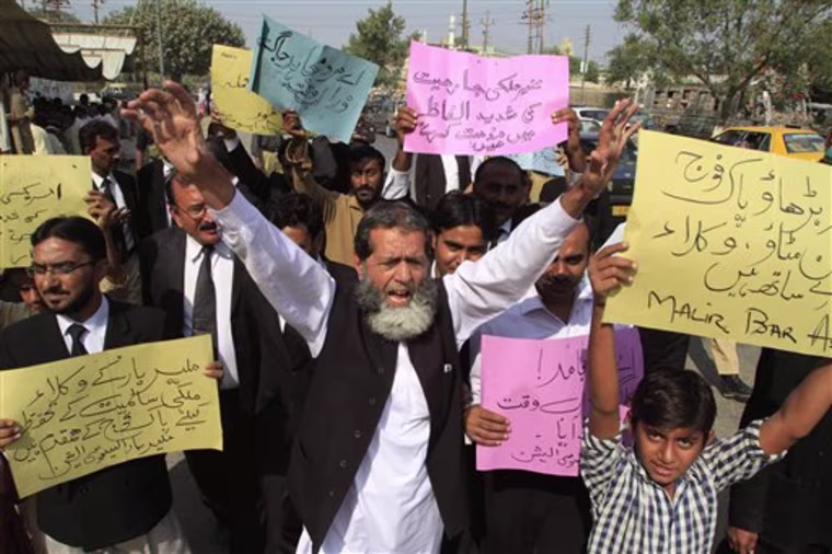 Pakistani lawyers rally to condemn NATO strikes on Pakistani troops, in Karachi, Pakistan, on Monday, Nov 28, 2011.  The NATO airstrikes that killed 24 Pakistani soldiers went on for almost two hours and continued even after Pakistani commanders had pleaded with coalition forces to stop, the army claimed Monday in charges that could further inflame anger in Pakistan. Placard on right reads \" Go ahead Pakistan army we are with you.\"(AP Photo/Shakil Adil)