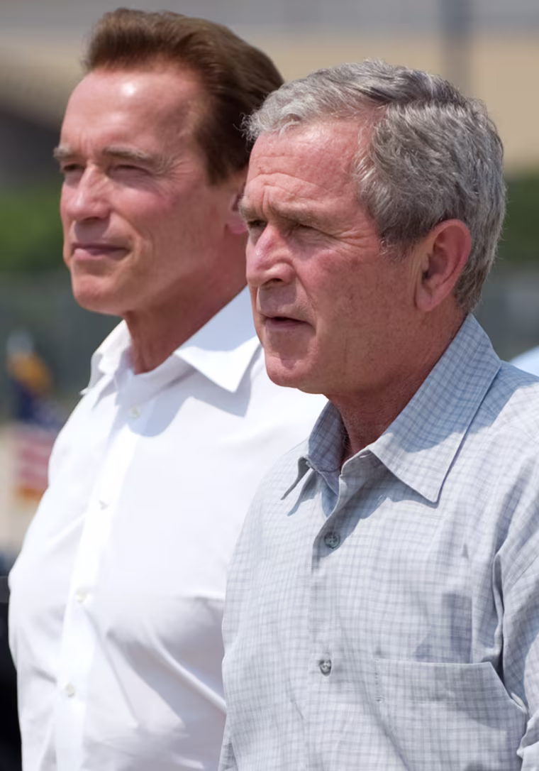 Image: US President George W. Bush (R) walks alongside California Governor Arnold Schwarzenegger