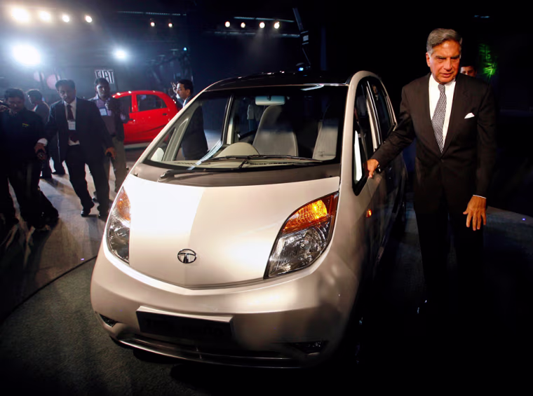 Image: India's Tata Group Chairman Tata poses with the company's new \"Nano\" car during its launch in New Delhi