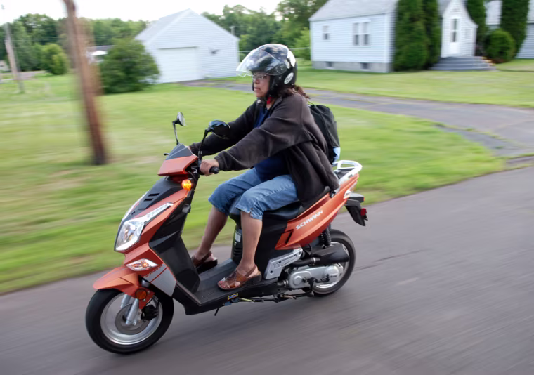 Image: Barbara Kennebeck rides her scooter to save on gas costs