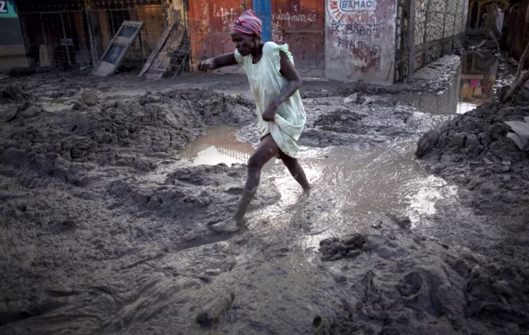 Image: A woman walks through mud in Gonaives, Haiti