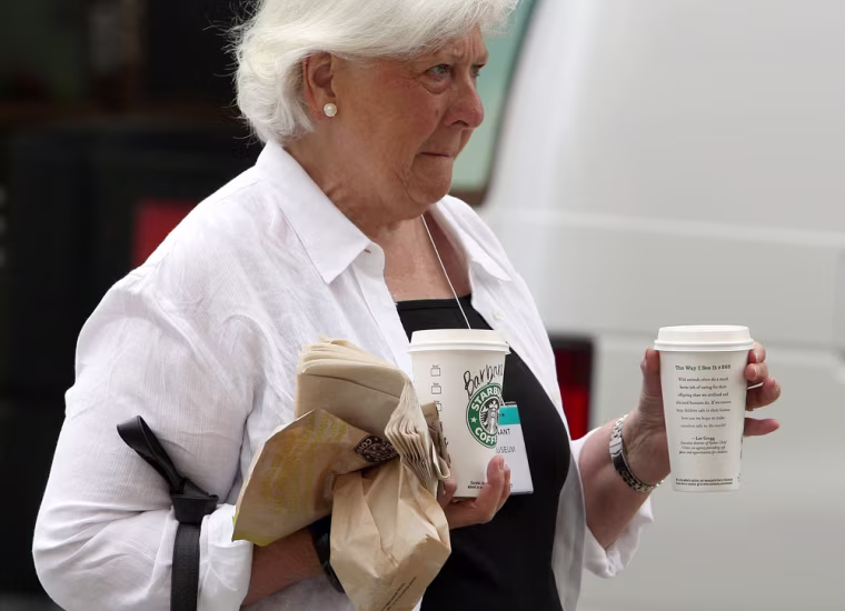 Image: A Starbucks customer carries drinks as she leaves a Starbucks store