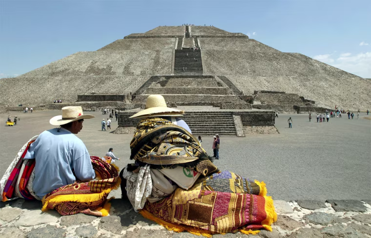 VENDORS SIT IN FRONT OF PYRAMID IN TEOTIHUACAN