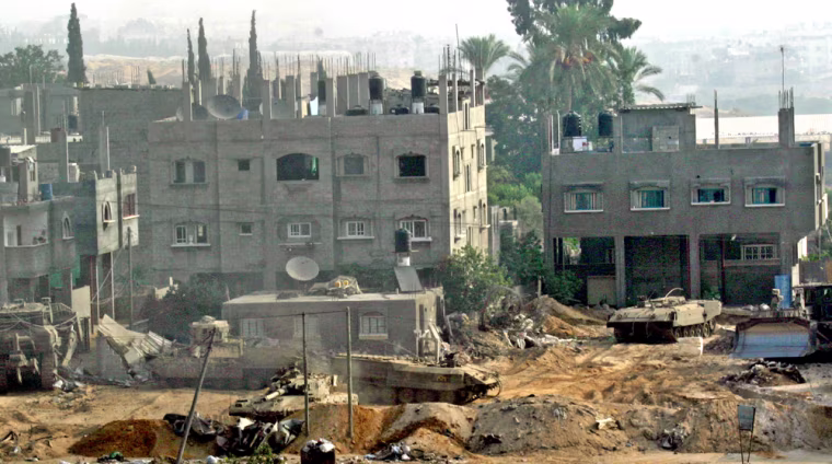 Israeli tanks and bulldozers are seen clearing the area during the Israeli army incursion in Beit Lahiya, in the northern Gaza Strip, Wednesday Sept. 29, 2004.  Late Tuesday, about 30 Israeli tanks moved into northern Gaza, witnesses said.  According to the army the purpose  is to stop Palestinian militants from firing rockets at nearby Israeli towns. Three Palestinians were killed including a Hamas militant and 10 wounded in an exchange of fire with Israeli forces. (AP Photo/Adel Hana)