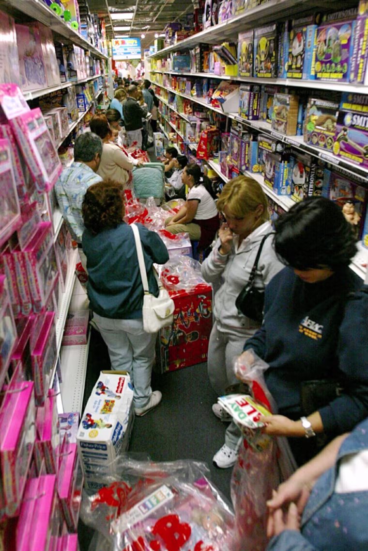 Early morning shoppers wait in a line that runs the store aisles at a KB Toys , in Miami, Friday Nov. 26 ,2004. The store opened at 5 am for it's one day sale. (AP Photo/Hillery Smith Shay)