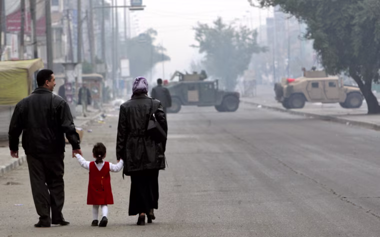 An Iraqi family approaches a  US Army checkpoint on their way to a polling station in Baghdad, Iraq, Sunday, Jan. 30, 2005 where Iraqis are lining up to vote in their country's first free election in a half-century. (AP Photo/Anja Niedringhaus)