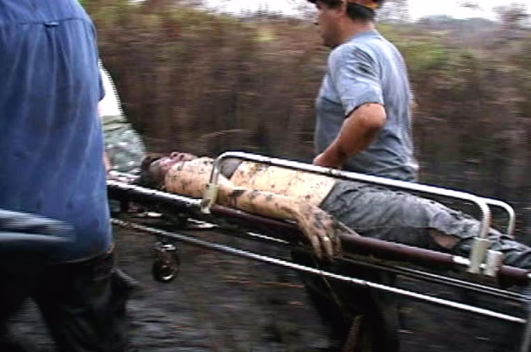 TV grab of rescue personnel carrying an