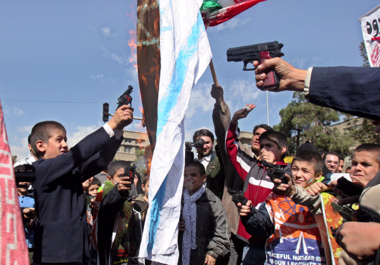 Iranian school boys shoot with their toy guns at an Israeli flag as it burns during an anti-Israeli rally marking \"Al-Quds Day\" (Jerusalem Day), to support the Palestinian cause, in Tehran, Iran, Friday, Oct. 28, 2005. Tens of thousands of Iranians staged anti-Israel protests across the country Friday and repeated calls by their ultraconservative president who repeated the words of the late Ayatollah Ruhollah Khomeini, founder of Iran's Islamic revolution, by saying: \"Israel must be wiped off the map.\"  (AP Photo/Vahid Salemi)