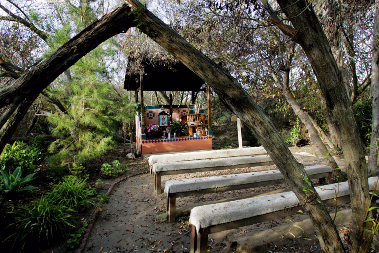 View of a makeshift chapel named, Our Lady of Mount Carmel, which holds church services for migrants living in surrounding camps, outside of Del Mar, Calif on Wednesday, Dec. 20, 2006.  For 20 years, many of the illegal immigrants drawn by jobs in tomato fields have worshipped at an outdoor church, a concrete altar in a canyon where they slept under the shelter of plywood and plastic tarps and bathed in a stream. Today, however, McGonigle Canyon is overshadowed by multimillion-dollar homes, and police and landowners want the eyesores gone. The squatters and their tree-covered place of worship, which the Roman Catholic church installed in the 1980s, are being expelled in one of the latest skirmishes in the nation's battle over illegal immigration and homeless squatters' camps. (AP Photo/Sandy Huffaker)