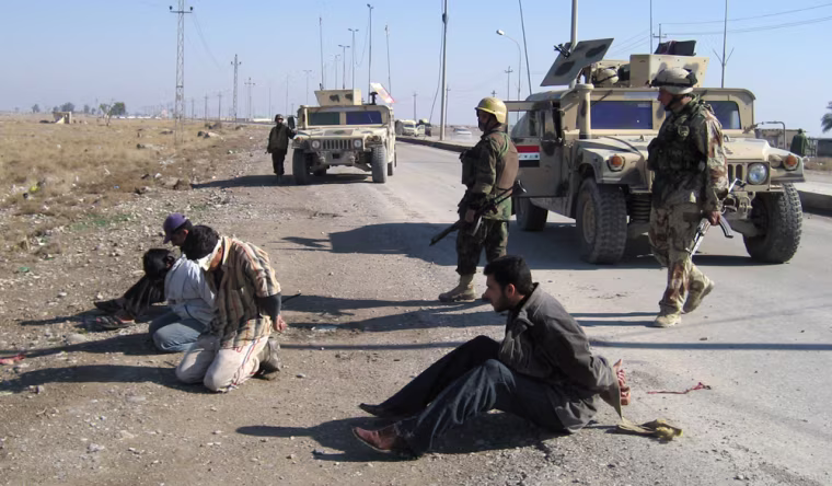 Blindfolded people are detained at the side of the road after an Iraqi army patrol came under attack in Baqouba, 60 kilometers (35 miles) northeast of Baghdad, Iraq, Wednesday Jan. 24 2007.  (AP Photo/Talal. M. al-Dean)