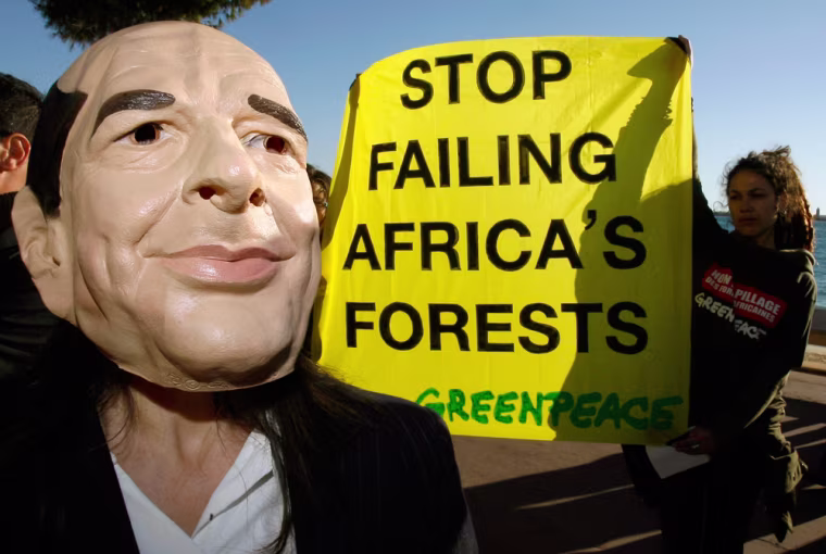 An activist from Greenpeace wears a mask of France's President Chirac during a demonstration in Cannes