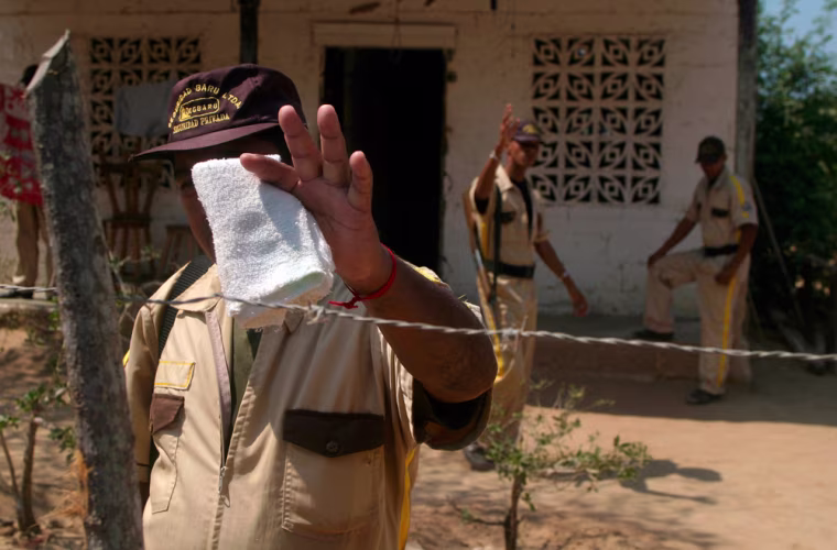 A security guard covers his face in Isla Baru