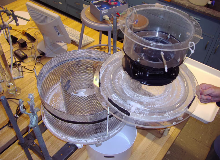** ADVANCE FOR FRIDAY MARCH 16 AND THEREAFTER ** This photo provided by Columbia University shows a prototype of an air capture device built by Columbia University researchers Klaus Lackner and Frank Zeman. It would suck carbon dioxide from the free-flowing air, perhaps near wind turbines, to help lessen global warming. The carbon dioxide would flow into the bowl at lower left, be separated with absorbent chemicals, then liquid carbon dioxide mix would flow into the bucket in the picture, bottom center, and air without carbon dioxide would flow out the top right corner container.  (AP Photo/Columbia University, Federico Barrai) ** NO SALES **