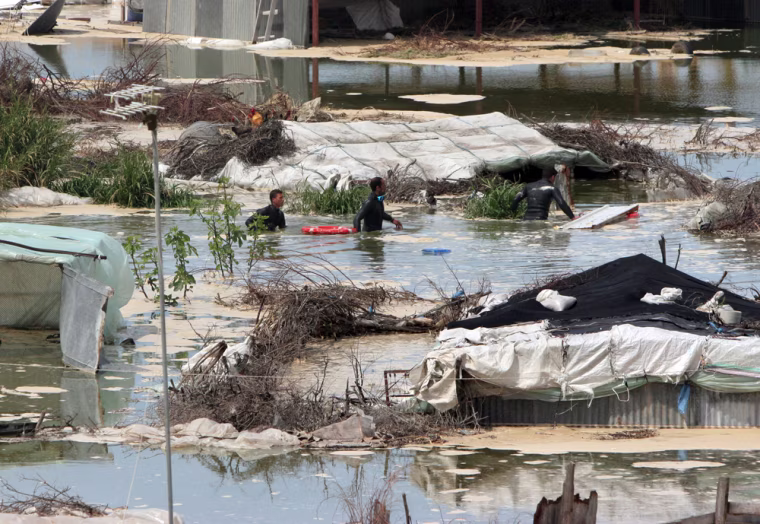 Palestinian rescue workers search for bodies amongst flooded houses after a cesspool embankment collapsed in the village of Umm Naser, in the northern Gaza Strip, Tuesday, March 27, 2007. An earth embankment around a cesspool suddenly collapsed Tuesday, spewing a river of sewage and mud that killed three people and forced residents to flee from this village in the northern Gaza Strip, officials said. A local official blamed shoddy infrastructure in Umm Naser, a town of 3,000, for the disaster. (AP Photo/Hatem Moussa)