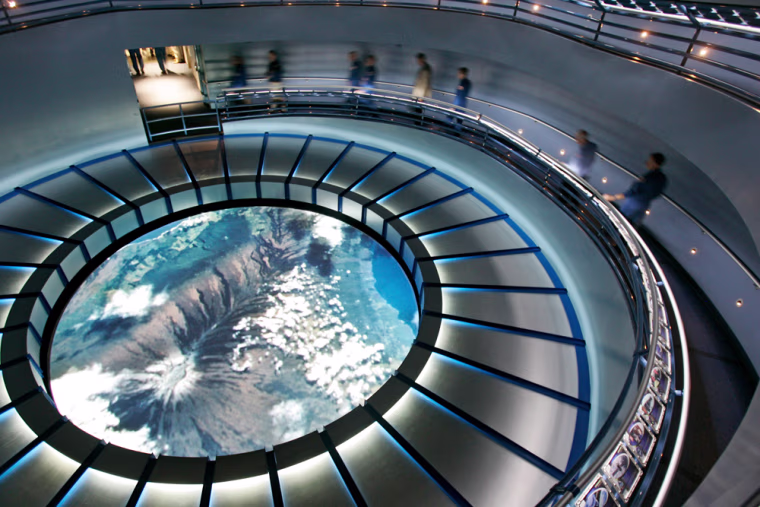 Former astronauts exit the Space Shuttle Experience launch simulator during the grand opening at the Kennedy Space Center Visitor Complex in Cape Canaveral, Fla., Friday, May 25, 2007. The exit has a spiral ramp with a simulated view of earth from outer space.(AP Photo/John Raoux)