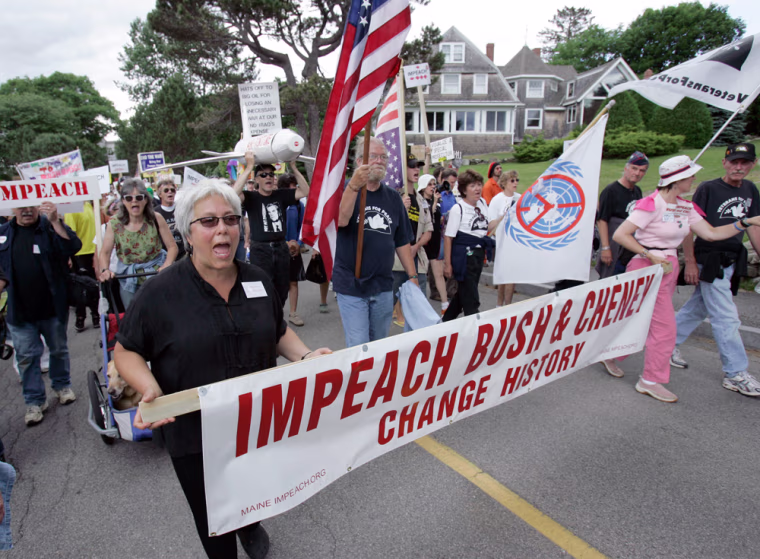 Protesters march toward the Bush family Walker's Point compound Sunday, July 1, 2007 in Kennebunkport, Maine where President George W. Bush will meet with Russia President Vladimir Putin later in the day. (AP Photo/Robert F. Bukaty)