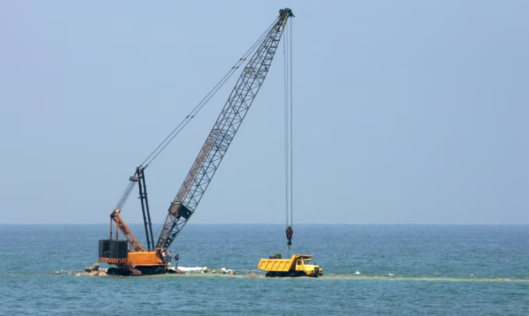 Rocks are unloaded by crane from a truck on a partially-completed coastal defense breakwater in Alexandria, Egypt, May 15, 2007. The Mediterranean Sea is creeping higher, flooding parts of the Egyptian shoreline in an inexorable process caused by global warming but in Egypt, as in much of Africa, global warming is rarely discussed and the debate over climate change is submerged by immediate problems such as poverty, disease and overpopulation. (AP Photo/Ben Curtis)